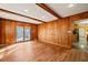 This living room boasts wooden walls, light wood floors, and recessed lighting adjacent to the kitchen at 405 Lookout Pt, Rougemont, NC 27572