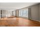 Sunlit living room with hardwood floors, large bay windows, and a staircase with white railings, offering comfort and style at 405 Lookout Pt, Rougemont, NC 27572