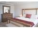 Cozy bedroom features a plush bed, wood dresser, and lots of natural light at 5006 Tura St, Raleigh, NC 27610