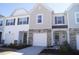 Inviting townhomes featuring stone accents, neutral siding, manicured landscaping, and attached garages at 5006 Tura St, Raleigh, NC 27610