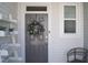 Close up of a gray front door adorned with a festive wreath with sidelight at 5006 Tura St, Raleigh, NC 27610