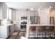 Modern kitchen boasts white cabinets, stainless steel appliances, quartz countertops, and elegant pendant lights at 5006 Tura St, Raleigh, NC 27610