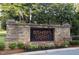 Stone community entrance sign with vibrant flower beds and lush greenery welcome residents and guests at 528 Opposition Way Way, Wake Forest, NC 27587