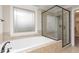 Bathroom showcasing a soaking tub, separate shower, and tiled walls at 6712 Stepherly Way, Holly Springs, NC 27540