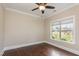 Empty bedroom featuring hardwood floors, a ceiling fan, and a window with a backyard view at 6712 Stepherly Way, Holly Springs, NC 27540