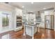Beautiful kitchen with white cabinets, stainless steel appliances, granite counters, and a kitchen island at 6712 Stepherly Way, Holly Springs, NC 27540