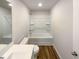 Spotless full bathroom with shower-tub combo, white fixtures, and wood-look flooring for a clean, modern look at 737 Little Patch St, Zebulon, NC 27597