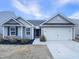 Charming single-story home with gray siding, attached garage, and manicured landscaping at 737 Little Patch St, Zebulon, NC 27597