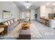 Bright, open living room featuring plush seating, neutral tones and seamless flow to the kitchen and dining area at 737 Little Patch St, Zebulon, NC 27597
