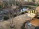 Large backyard with well-maintained lawn, outdoor kitchen, and a scenic pond at 7520 Channery Way, Raleigh, NC 27616