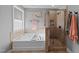 A luxurious bathroom featuring a soaking tub, walk-in shower, and neutral tile work offers a spa-like experience at 7520 Channery Way, Raleigh, NC 27616