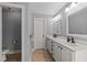 Bright bathroom with double sinks, white cabinetry, and a separate toilet room offers a clean and functional space at 7520 Channery Way, Raleigh, NC 27616