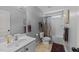 Bathroom with a single sink vanity, tiled floors, and a shower-tub combination with curtain at 7520 Channery Way, Raleigh, NC 27616