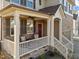 Inviting front porch with stone accents, seating, and a charming red door at 7520 Channery Way, Raleigh, NC 27616