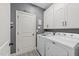Functional laundry room with white cabinets, washer, and dryer at 7520 Channery Way, Raleigh, NC 27616