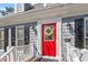 Inviting red front door with a wreath, flanked by elegant lighting fixtures and house number display at 8617 Canoe Ct, Raleigh, NC 27615