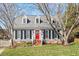 Charming two-story home with a red front door and dormer windows, nestled in a well-manicured lawn and mature trees at 8617 Canoe Ct, Raleigh, NC 27615