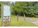 Entrance to the community greenway with signs, mature trees, and a paved path at 8617 Canoe Ct, Raleigh, NC 27615