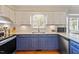Updated kitchen features stainless steel appliances, white cabinets and subway tile, and custom blue cabinets at 8617 Canoe Ct, Raleigh, NC 27615