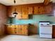Kitchen with paneled walls, wooden cabinets, laminate countertops, and a vintage stove at 1006 Stallings Rd, Durham, NC 27703
