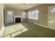 Bright living room with fireplace, natural light from windows and green carpet throughout at 1006 Stallings Rd, Durham, NC 27703