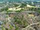 An aerial view of the property showcasing the neighborhood, golf course and surrounding trees at 1013 Traders Trl, Wake Forest, NC 27587