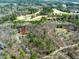 Aerial view of a property surrounded by trees and a golf course in the distance at 1013 Traders Trl, Wake Forest, NC 27587