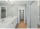 Well-lit bathroom with double sink vanity, wood floors, walk-in closet, and glass door shower at 1013 Traders Trl, Wake Forest, NC 27587