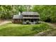 A two-story brick home with a inviting front porch, surrounded by lush trees and green lawn at 1013 Traders Trl, Wake Forest, NC 27587