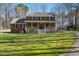 Two-story brick home with a inviting front porch surrounded by a well manicured green lawn at 1013 Traders Trl, Wake Forest, NC 27587