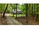 Charming brick home with a welcoming front porch and a long driveway through a lush green forest at 1013 Traders Trl, Wake Forest, NC 27587