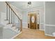 Bright foyer with wood floors, staircase, and a decorative front door with sidelights at 1013 Traders Trl, Wake Forest, NC 27587