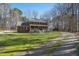 Traditional brick home with a welcoming front porch, surrounded by a large lawn and mature trees at 1013 Traders Trl, Wake Forest, NC 27587