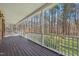 Inviting covered front porch with a wooden floor and white railing overlooking a wooded area at 1013 Traders Trl, Wake Forest, NC 27587