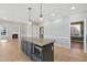 Open kitchen with granite island, stainless microwave, and modern pendant lighting at 1013 Traders Trl, Wake Forest, NC 27587