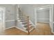 Interior shot of a staircase with hardwood steps and black metal railing in a neutral-toned home at 1013 Traders Trl, Wake Forest, NC 27587