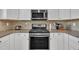 This kitchen features stainless steel appliances, granite countertops, and white cabinetry at 10510 Sablewood Dr # 108, Raleigh, NC 27617