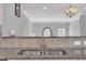 Close up view of stainless steel sink, granite countertops, white cabinetry, and a chandelier in dining area at 10510 Sablewood Dr # 108, Raleigh, NC 27617