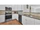 This kitchen features stainless steel appliances, granite countertops, and white cabinetry at 10510 Sablewood Dr # 108, Raleigh, NC 27617