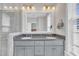 A luxurious bathroom with a double vanity, gray cabinets, and a large mirror at 10510 Sablewood Dr # 108, Raleigh, NC 27617