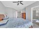 A cozy bedroom with a ceiling fan, dresser, and en-suite bathroom at 10510 Sablewood Dr # 108, Raleigh, NC 27617