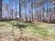 Expansive backyard features lush greenery, mature trees, and a wooden fence for added privacy at 110 Chickasaw Cir, Clayton, NC 27527