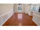 Bright dining area with wood floors, a modern light fixture, and large windows overlooking the backyard at 110 Chickasaw Cir, Clayton, NC 27527