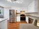 Updated kitchen with stainless steel appliances, white cabinets, and hardwood floors at 110 Chickasaw Cir, Clayton, NC 27527