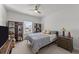 Cozy bedroom featuring two wooden bookshelves, a bed, a nightstand with a lamp, a window and a ceiling fan at 112 Ava Ct, Holly Springs, NC 27540