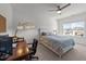 Bright bedroom with white walls, ceiling fan, large window and a wooden desk and chair at 112 Ava Ct, Holly Springs, NC 27540