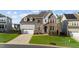 Beautiful two-story home showcasing stone, brick, and siding accents, a two-car garage, and a well-maintained front yard at 112 Ava Ct, Holly Springs, NC 27540