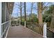 Cozy back porch featuring wood flooring, decorative railing, and serene views of the landscaped backyard at 113 Preston Pines Dr, Cary, NC 27513