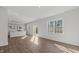 Bright and open-concept living space with sleek wood floors, leading to a modern kitchen and dining area at 117 Pisgah St, Sanford, NC 27330