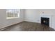 Spacious living room features a cozy fireplace, large window and beautiful wood-look flooring at 117 Pisgah St, Sanford, NC 27330